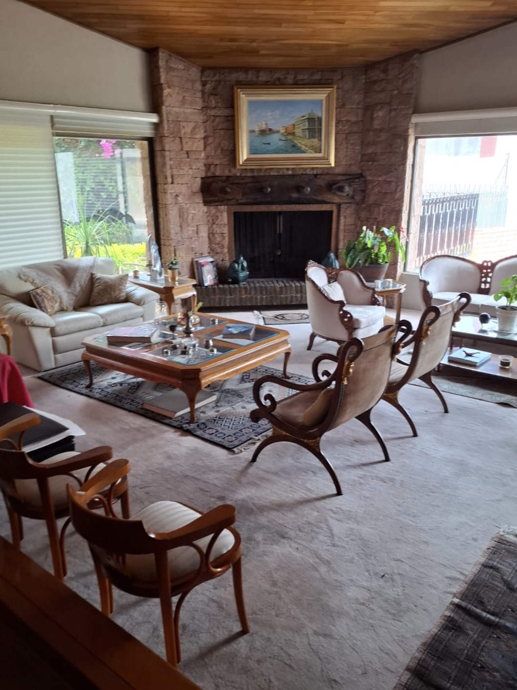 Sala principal con chimenea de cantera y techos de madera