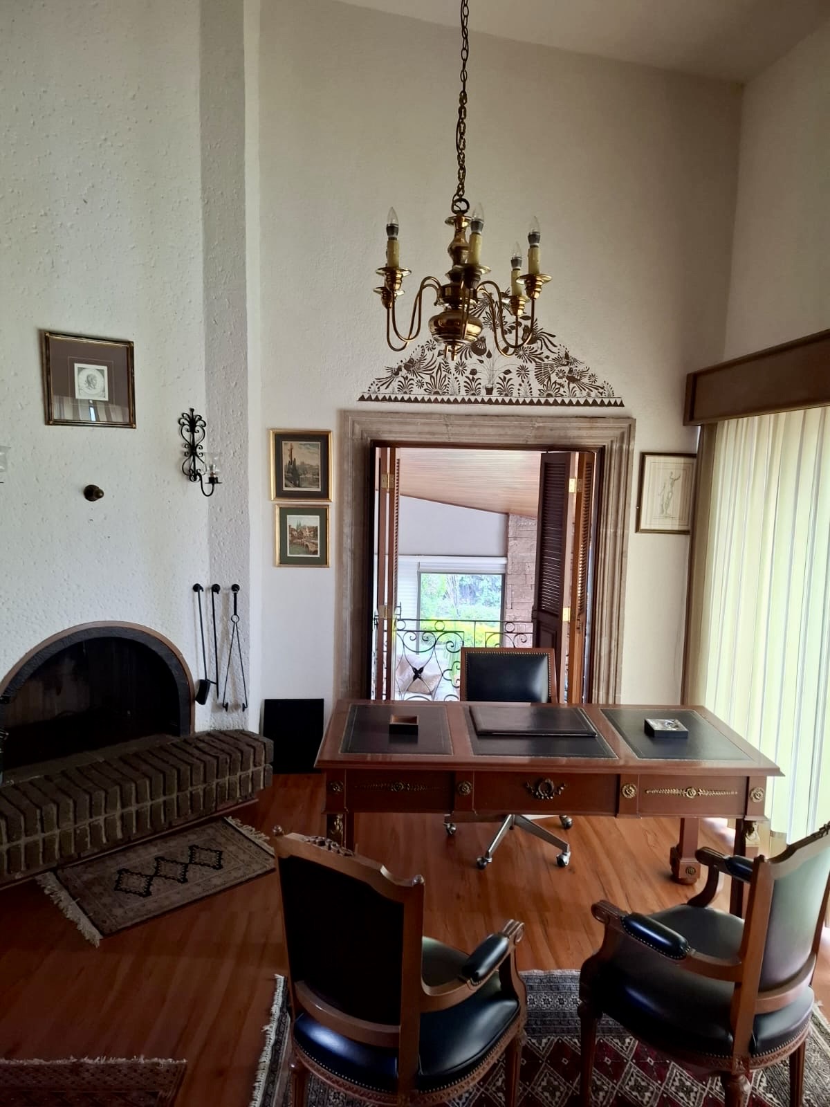 Estudio con chimenea, candil y balcón de hierro forjado